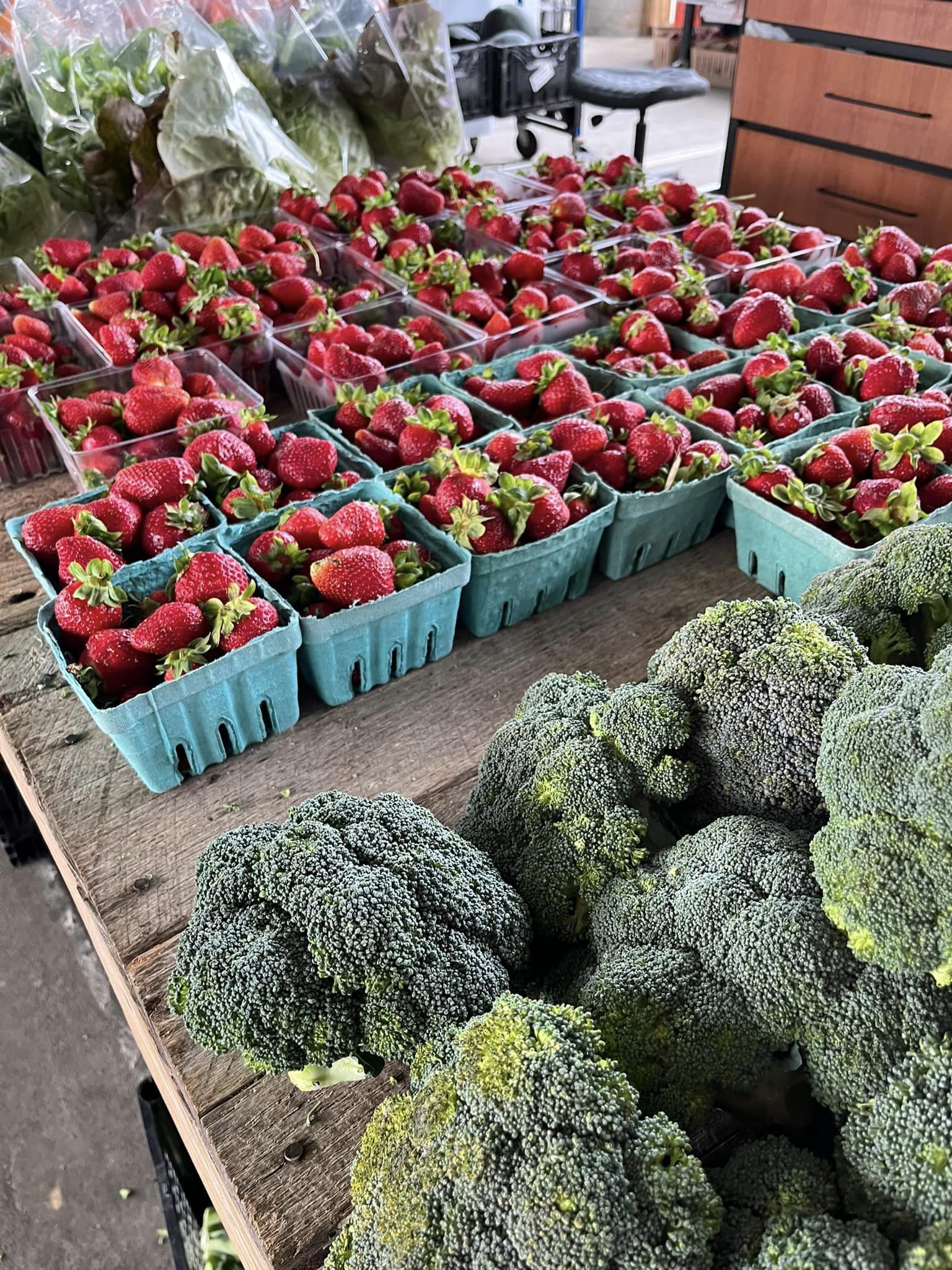 strawberries and broccoli for sale at a market