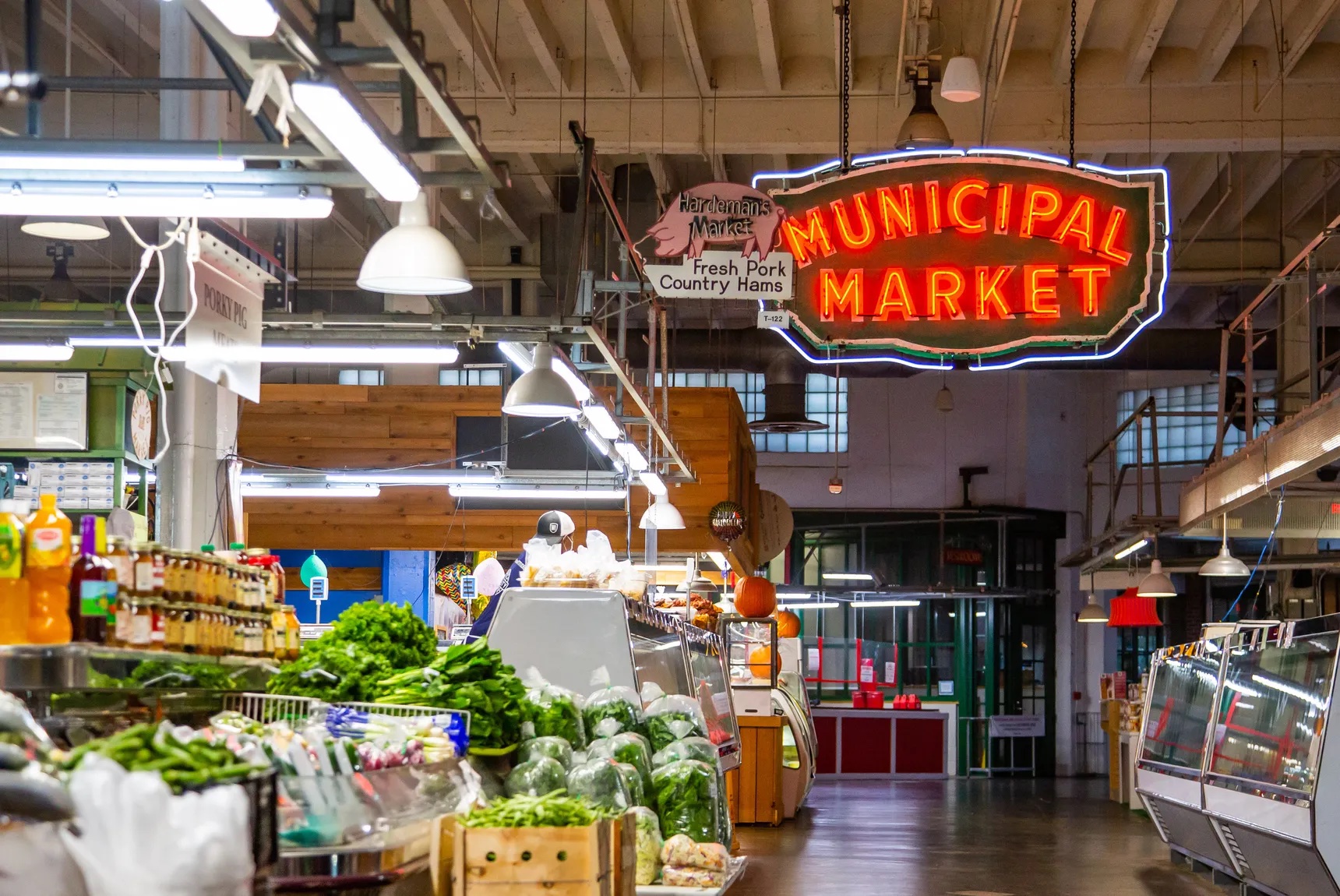 Picture of the Municipal Market Sign with produce and other market stalls.