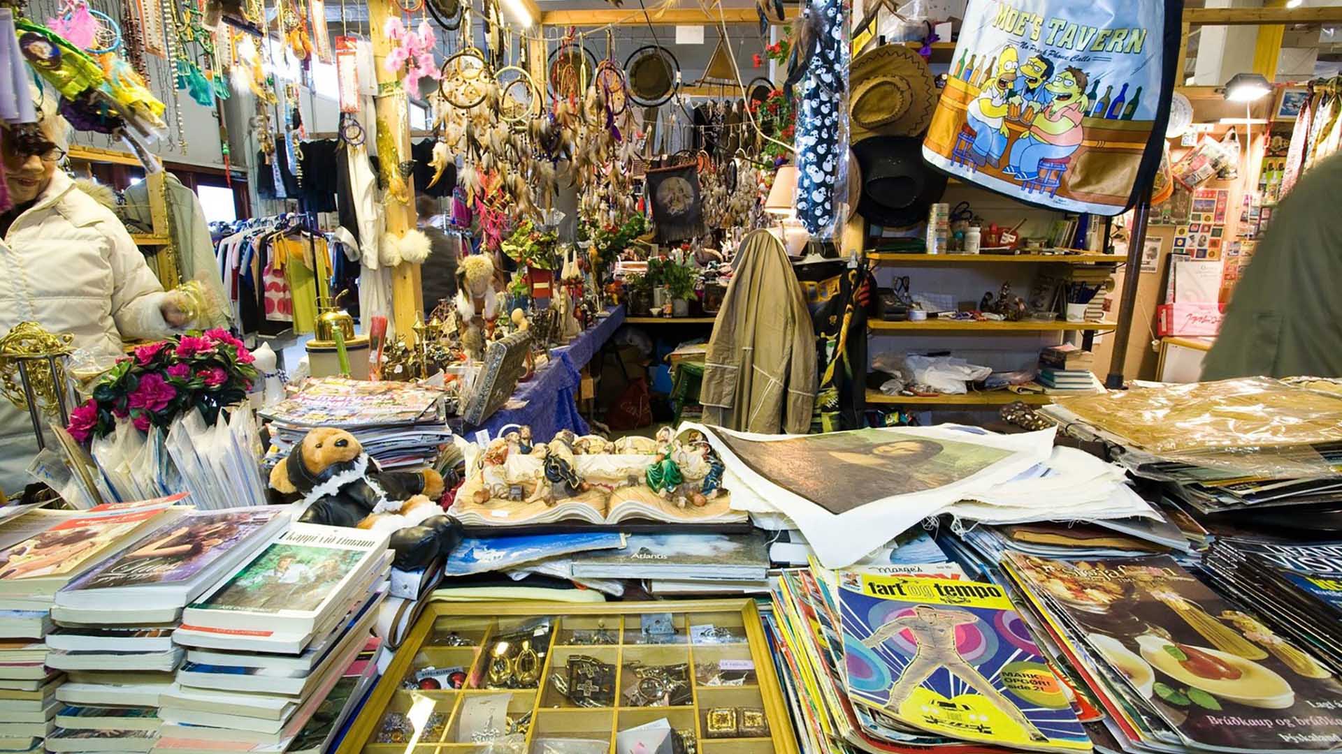 magazines, books and other finds piled on a table and at a market stall.